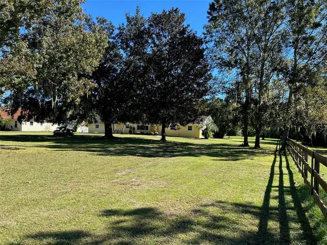 a view of a swimming pool with a patio and a yard