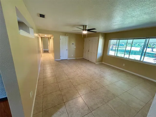 a view of hallway with a window and chandelier