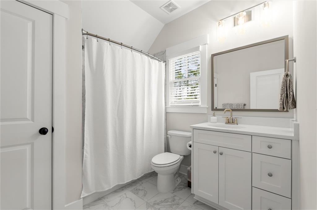3809 Cochran Lake Road Marietta, GA 30062 - Photo 30 of 40 a bathroom with a toilet a sink a mirror a window and vanity