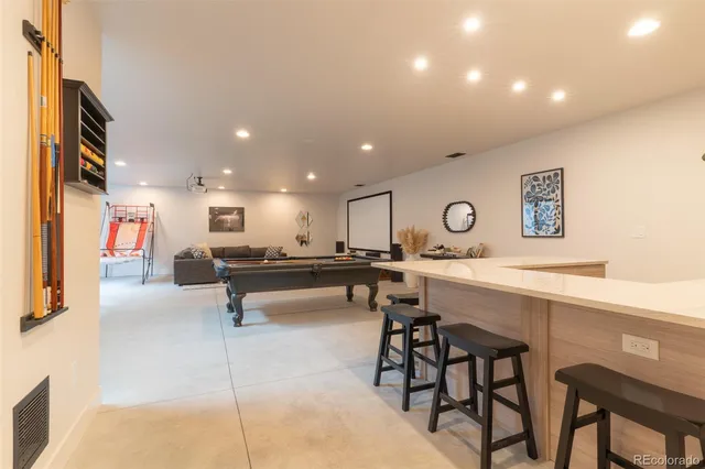 a living room with stainless steel appliances kitchen island a table and chairs
