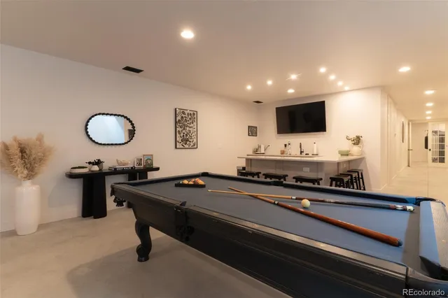 a living room with furniture pool table and a flat screen tv