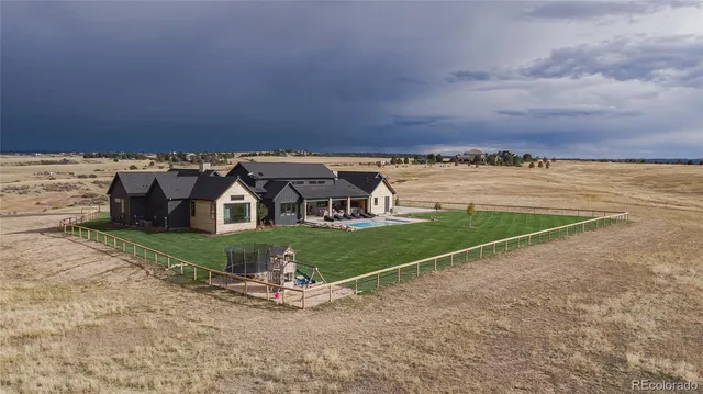a view of a house with a yard and a large parking space