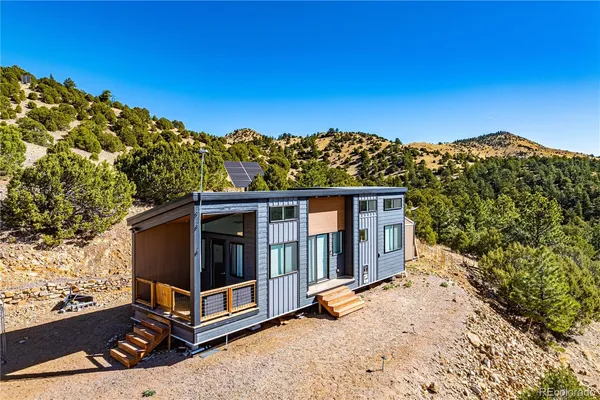 a view of a small house with a big yard
