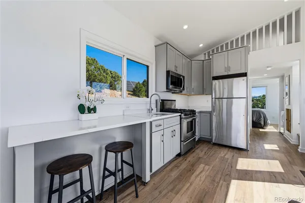 a kitchen with white cabinets and stainless steel appliances