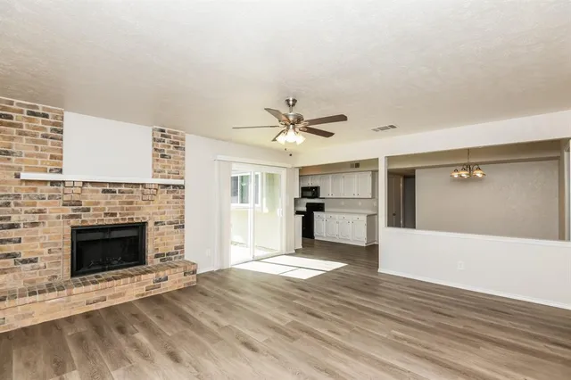 a view of an empty room with a fireplace and a window