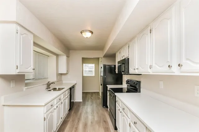 a kitchen with cabinets appliances a sink and a center island