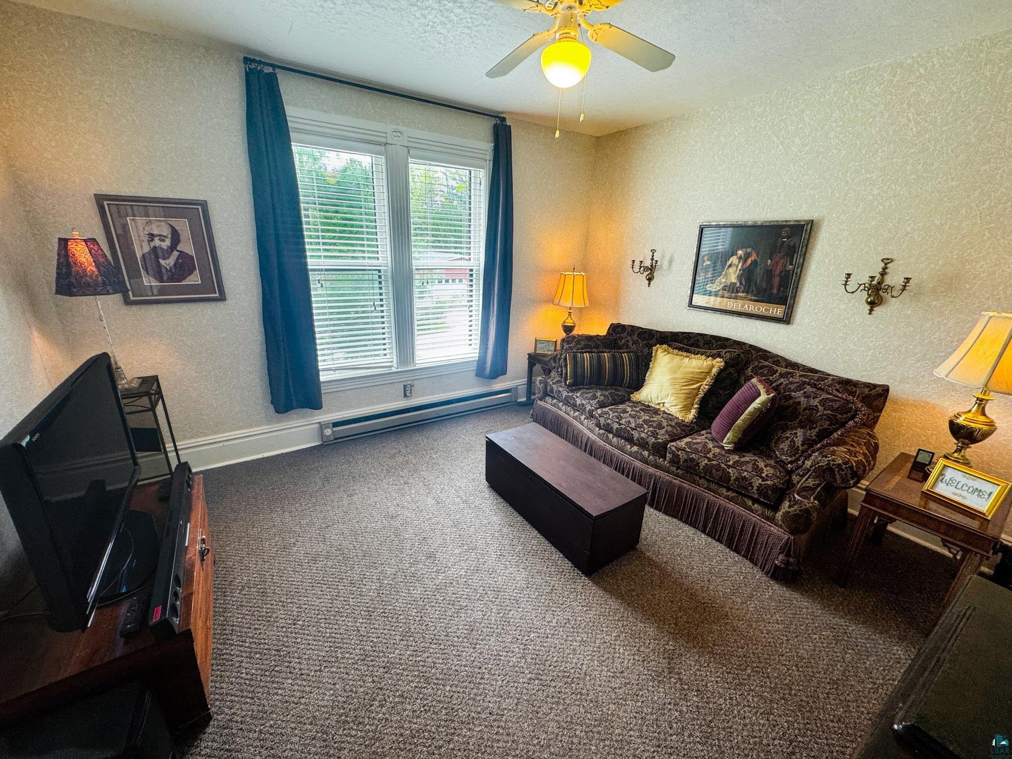 303 East 5th Street Washburn, WI 54891 - Photo 30 of 34 Carpeted interior space featuring a window with white blinds and blue drapes