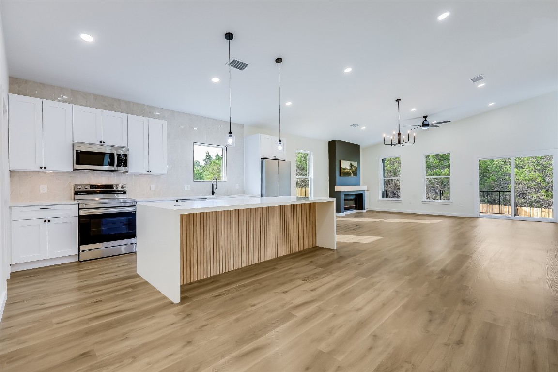 21216 Santa Rosa Avenue Lago Vista, TX 78645 - Photo 1 of 1 a large kitchen with stainless steel appliances granite countertop a stove a sink a refrigerator and a wooden floors