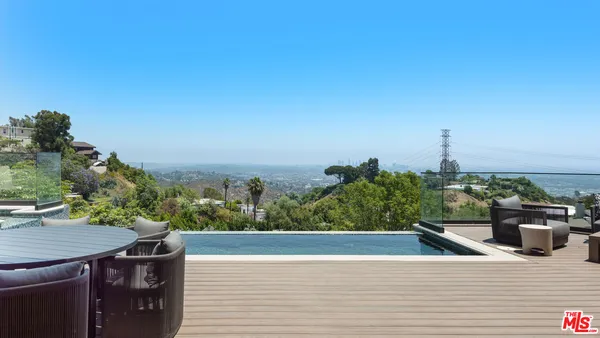 a view of a balcony with two chairs and a potted plant