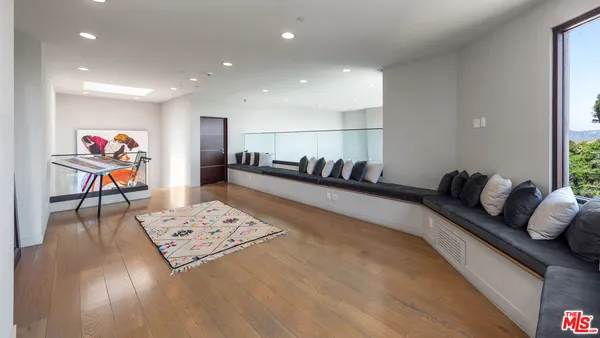 a large white bedroom with a large bed and large windows