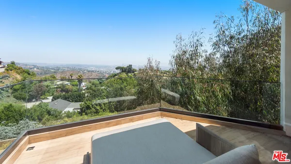 a view of a room with a large window and wooden floor
