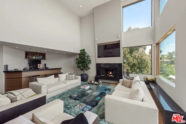 a living room with furniture fireplace and a large window