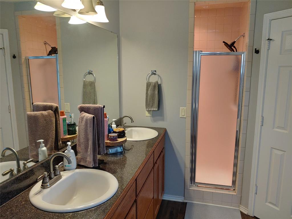 836 Airport Road Reno, TX 75462 - Photo 15 of 30 Double vanity with undermount sinks and a dark granite-finish countertop