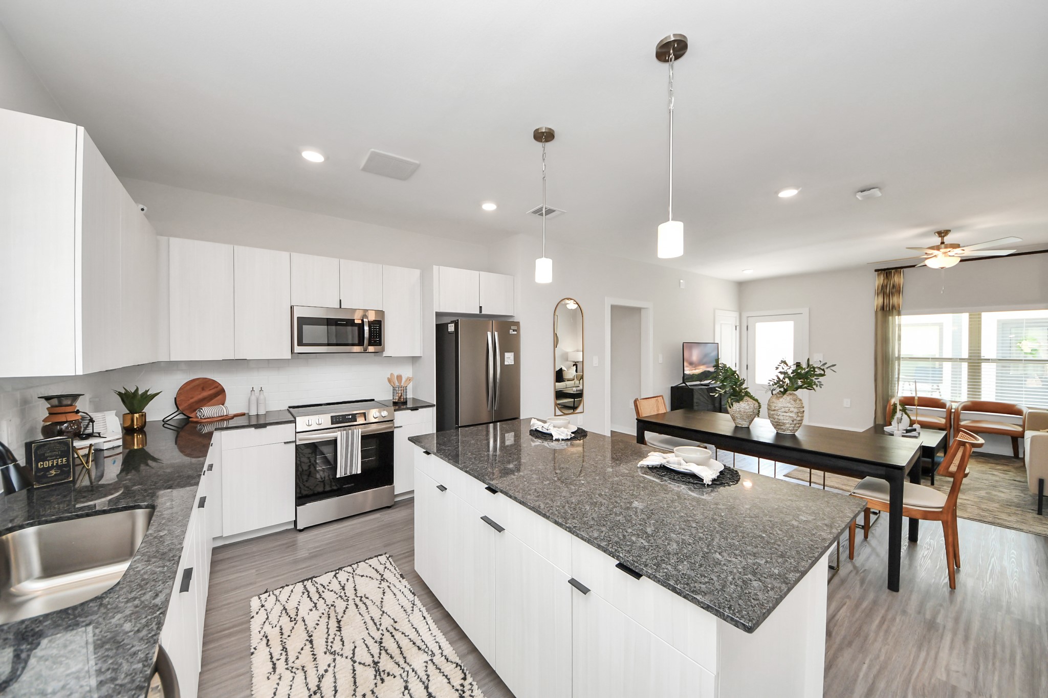 7711 Longmire Road, Unit 2 Conroe, TX 77304 - Photo 46 of 48 Boasting luxury finishes-stylish Island kitchen,granite counters,subway tile backsplash,ample custom cabinet space,stainless appliances,refrigerator,full size washer&dryer included,wood-like flooring throughout,open concept floor plan.