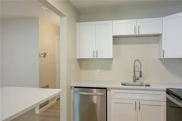 a kitchen with a sink cabinets and appliances