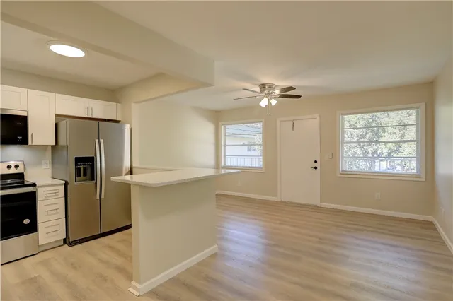 a view of a kitchen with a dishwasher cabinets and a large window