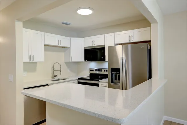 a kitchen with stainless steel appliances a refrigerator stove microwave and sink