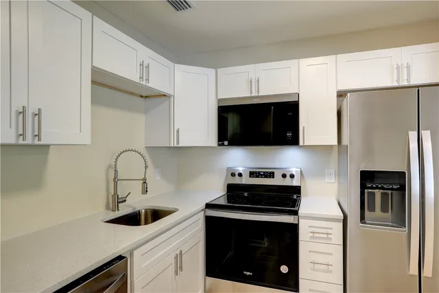 a kitchen with stainless steel appliances a stove microwave and a refrigerator