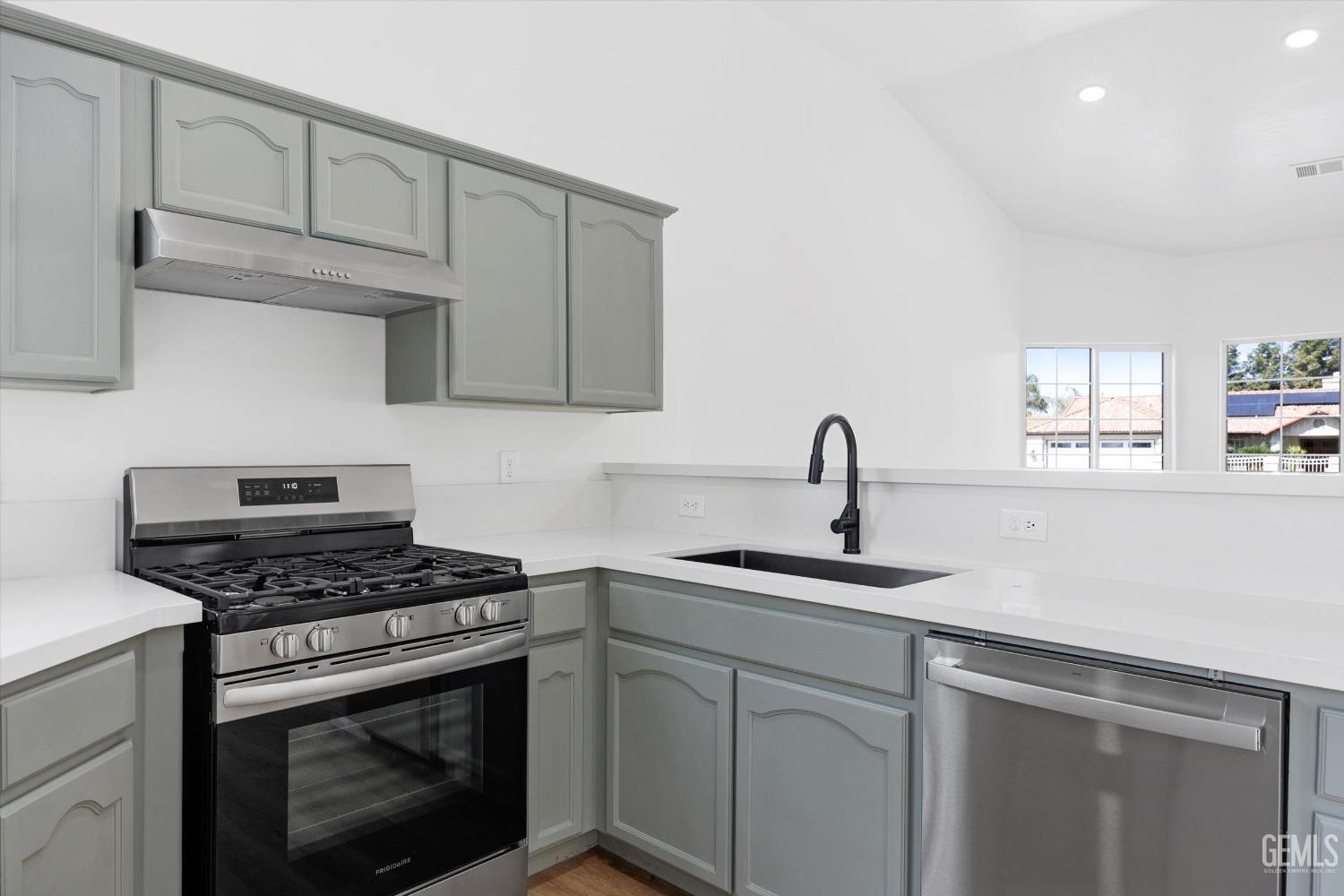 Undisclosed Address Bakersfield, CA 93306 - Photo 13 of 32 a kitchen with white cabinets sink and appliances