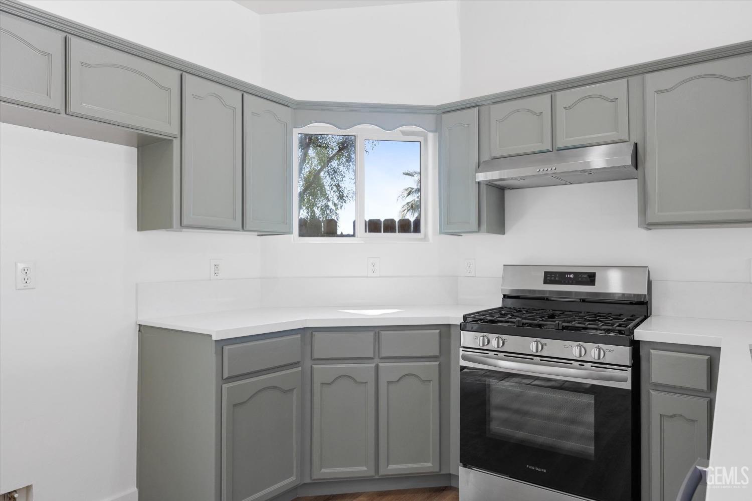 Undisclosed Address Bakersfield, CA 93306 - Photo 14 of 32 a kitchen with white cabinets and appliances