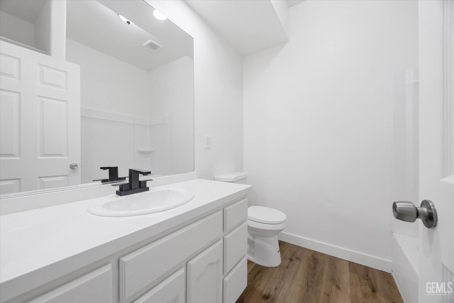 Undisclosed Address Bakersfield, CA 93306 - Photo 23 of 32 a bathroom with a sink a toilet a vanity and mirror