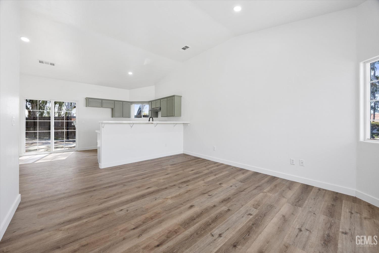 Undisclosed Address Bakersfield, CA 93306 - Photo 5 of 32 a view of empty room with wooden floor and kitchen