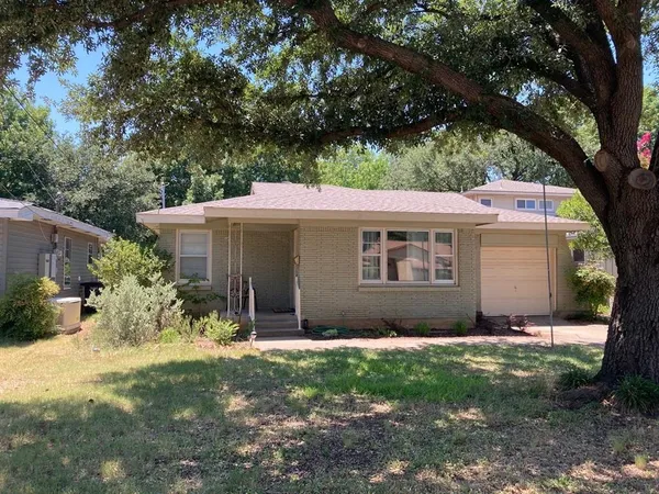 a view of a house with a yard and a large tree