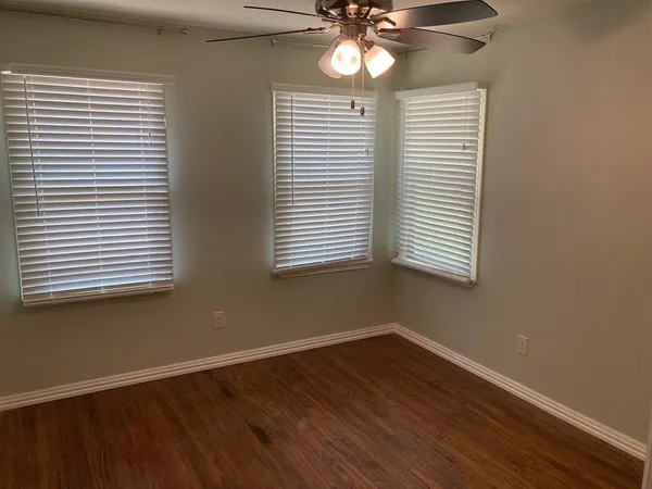 a view of a room with wooden floor and windows