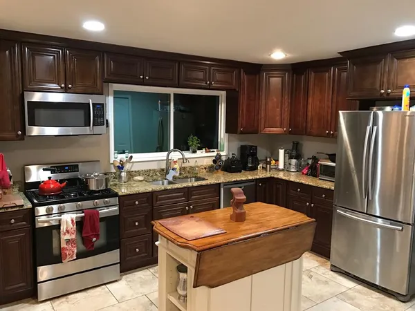 a kitchen with stainless steel appliances granite countertop a refrigerator stove and microwave