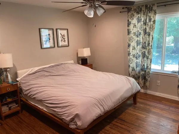 a large bed sitting in a bedroom next to a window
