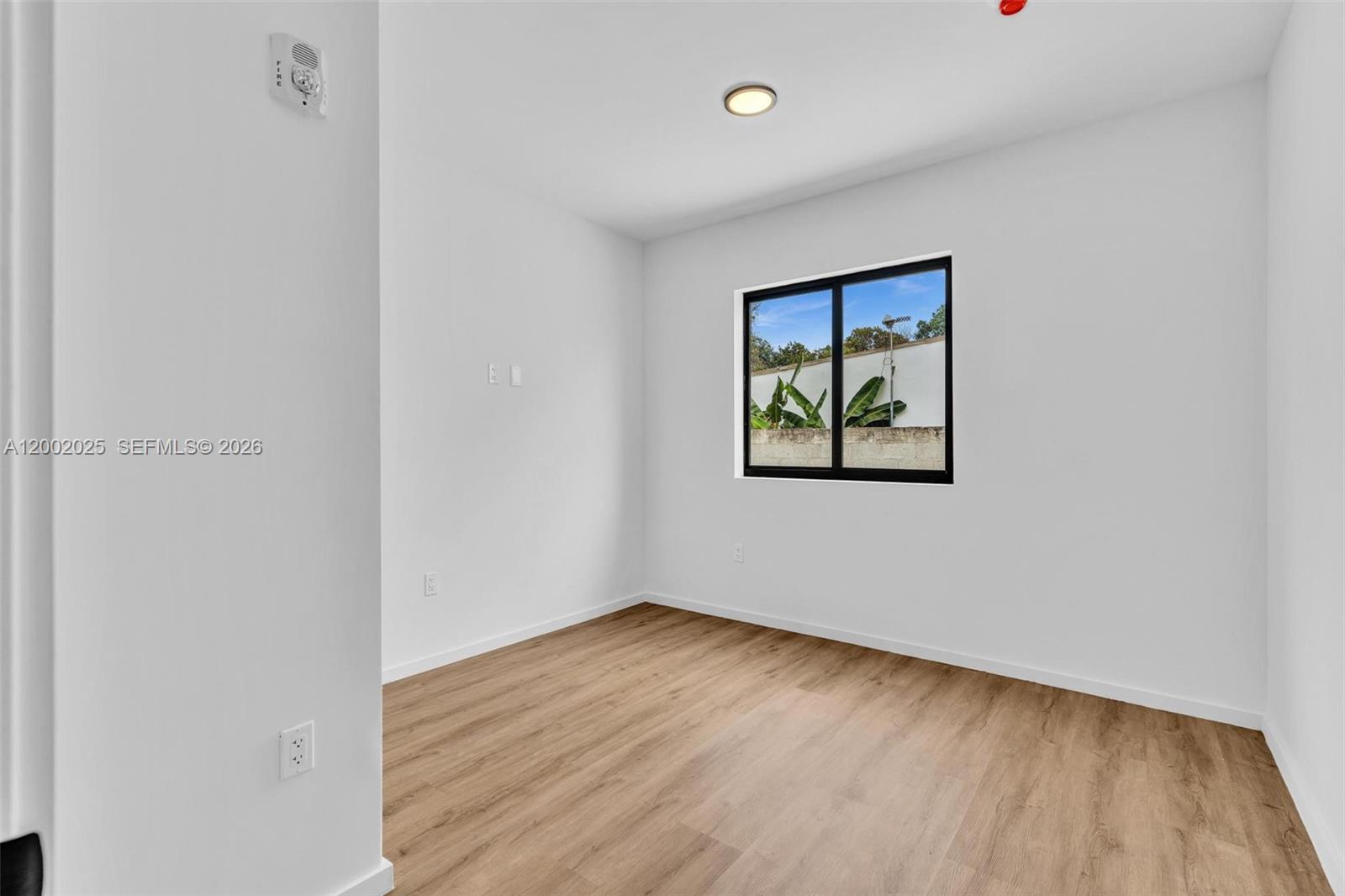 753 Northwest 30th Street, Unit 3 Miami, FL 33127 - Photo 13 of 35 an empty room with wooden floor and windows