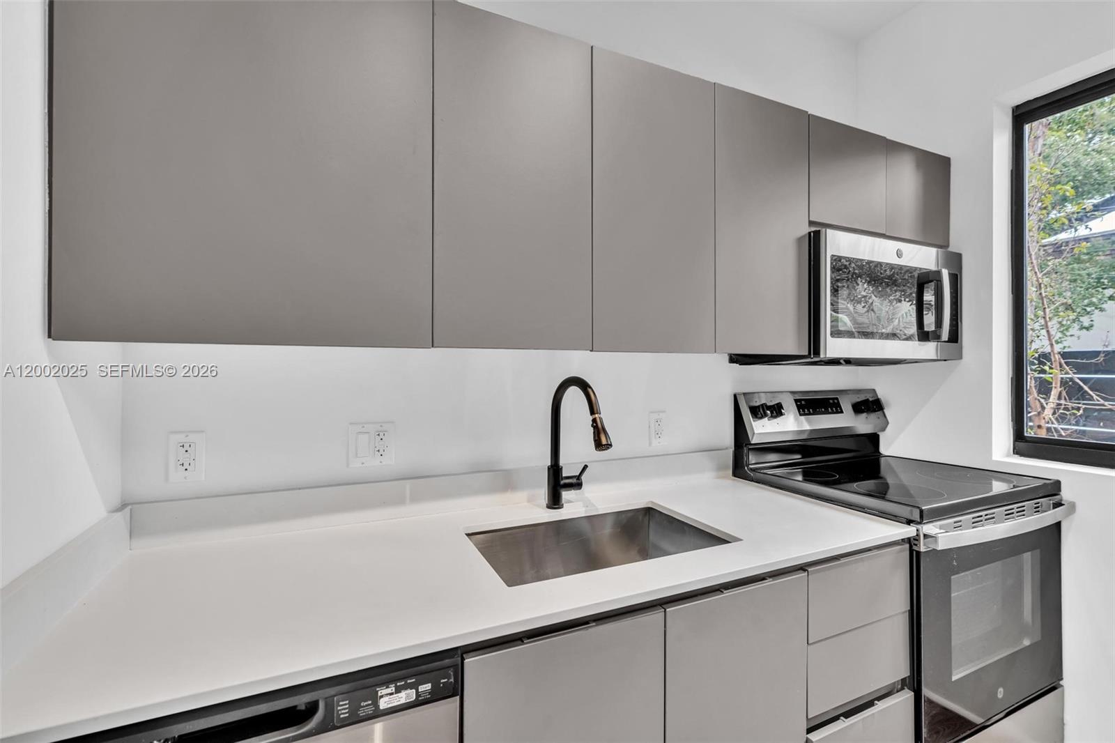 753 Northwest 30th Street, Unit 3 Miami, FL 33127 - Photo 20 of 35 a kitchen with a sink cabinets and appliances