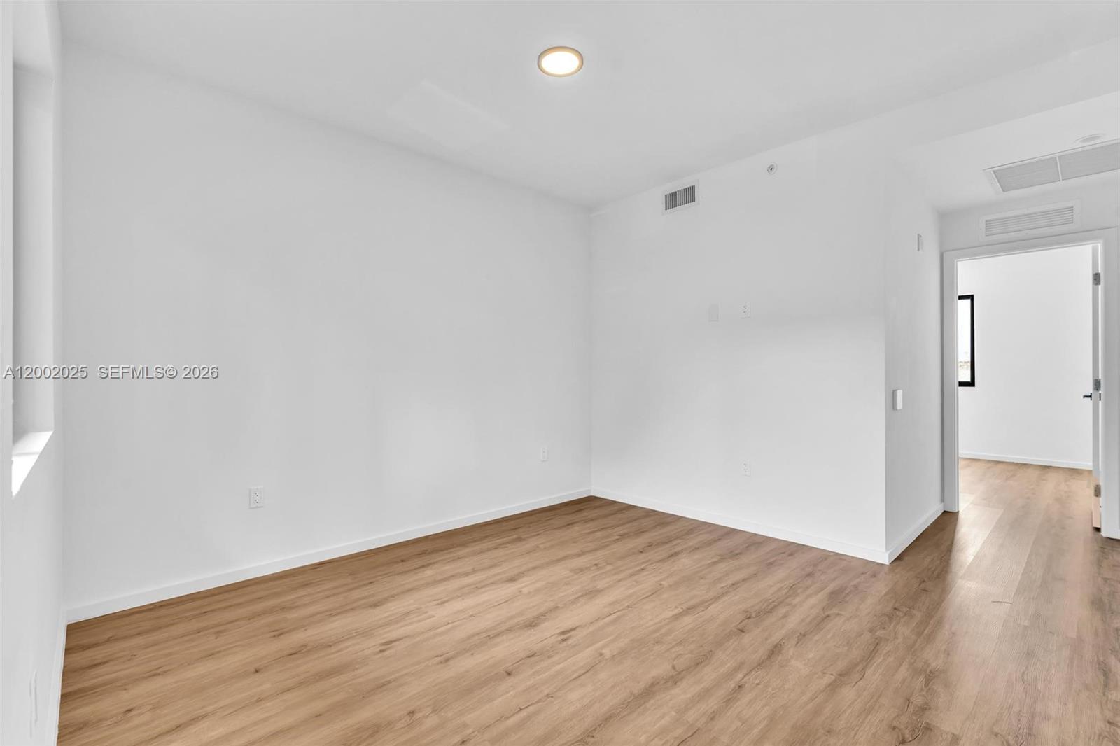 753 Northwest 30th Street, Unit 3 Miami, FL 33127 - Photo 5 of 35 a view of a room with wooden floor and white walls