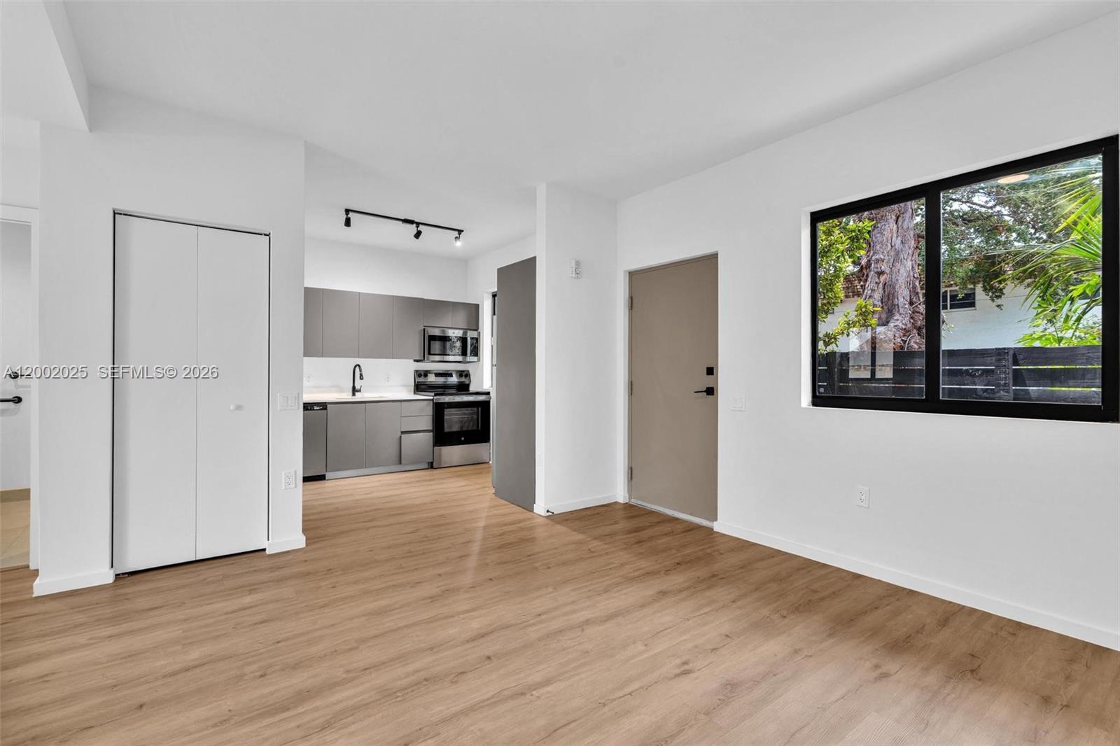 753 Northwest 30th Street, Unit 3 Miami, FL 33127 - Photo 7 of 35 a view of a kitchen with wooden floor and a window