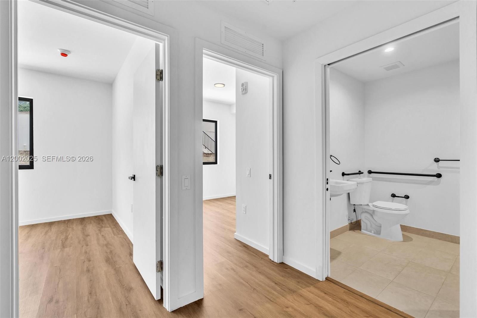 753 Northwest 30th Street, Unit 3 Miami, FL 33127 - Photo 8 of 35 a view of a hallway with wooden floor and a bathroom