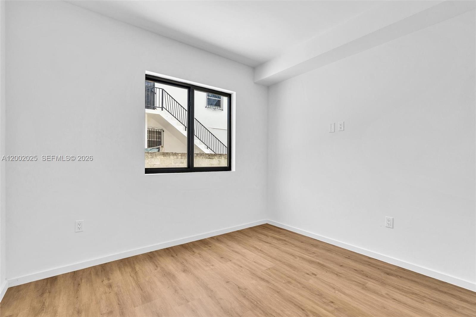753 Northwest 30th Street, Unit 3 Miami, FL 33127 - Photo 10 of 35 an empty room with wooden floor and windows
