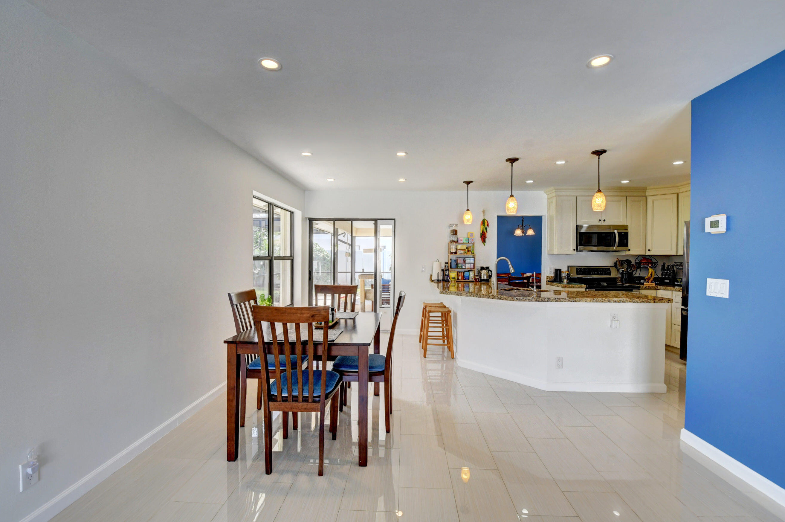 4192 Woods End Road Boca Raton, FL 33487 - Photo 21 of 63 a kitchen with a dining table chairs and white stainless steel appliances