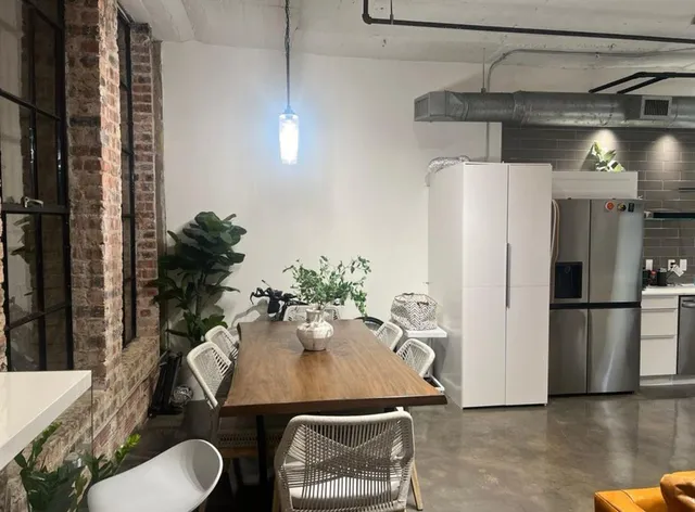 a dining room with furniture and a refrigerator