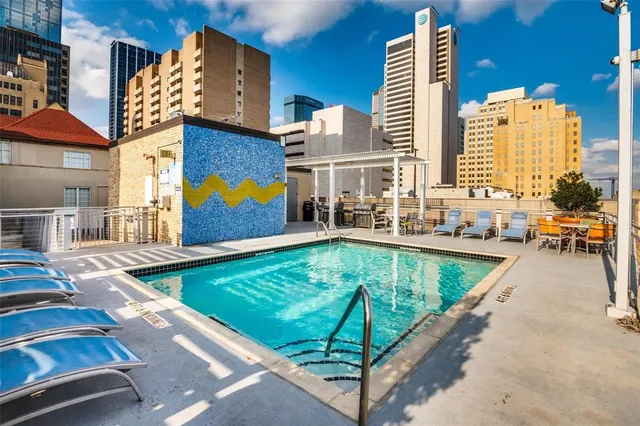 an aerial view of a swimming pool with outdoor seating