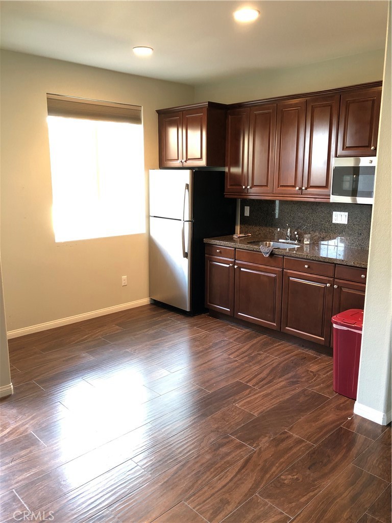 41299 St Croix Temecula, CA 92591 - Photo 6 of 17 a kitchen with stainless steel appliances granite countertop a stove a refrigerator a sink and dishwasher with wooden floor