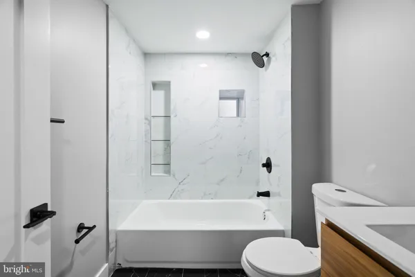 a bathroom with a bathtub toilet and a shower