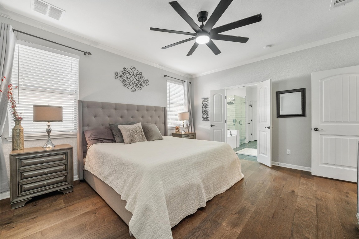 12404 Mediterra Place Austin, TX 78732 - Photo 20 of 39 a bedroom with a large bed and a chandelier