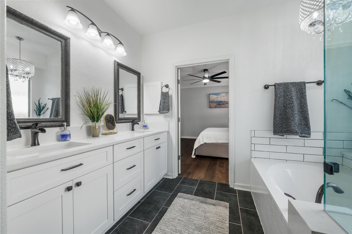 12404 Mediterra Place Austin, TX 78732 - Photo 22 of 39 a en suite bathroom with a double vanity sink a mirror and shower