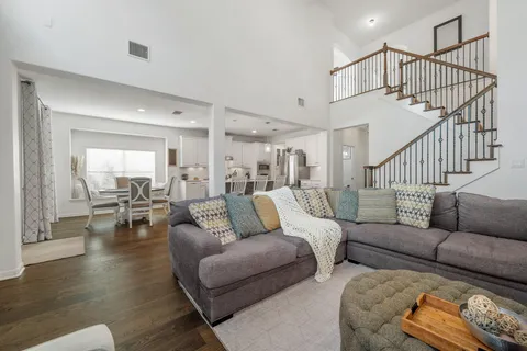 a living room with furniture and wooden floor next to a window