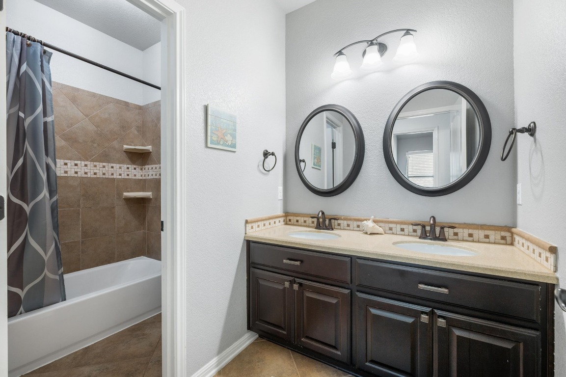 12404 Mediterra Place Austin, TX 78732 - Photo 32 of 39 a bathroom with a double vanity sink and a mirror