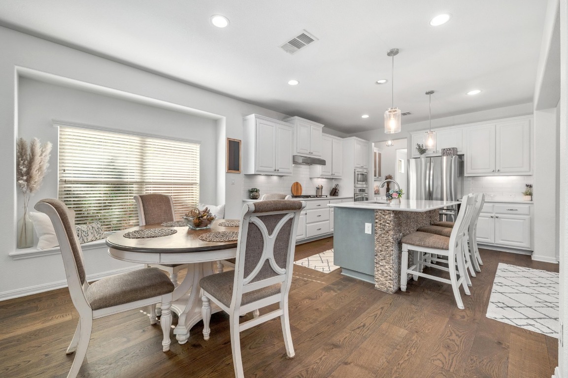 12404 Mediterra Place Austin, TX 78732 - Photo 5 of 39 a dining room with kitchen island furniture a window and appliances