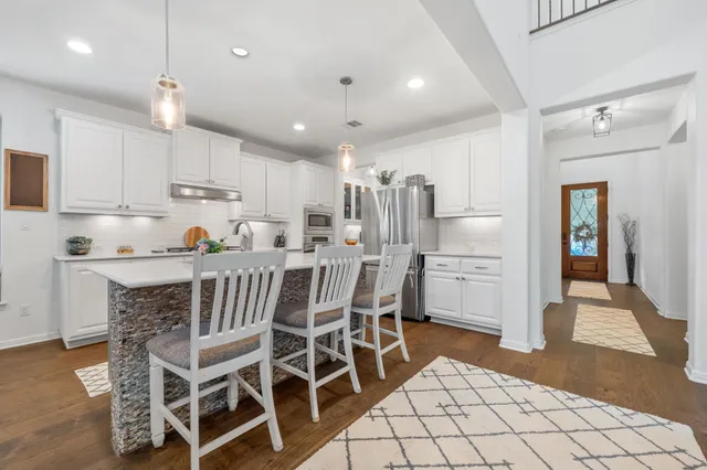 a kitchen with stainless steel appliances granite countertop a sink and a refrigerator
