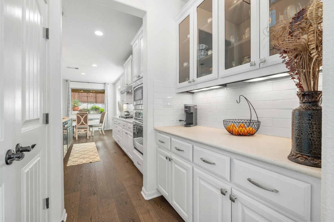 12404 Mediterra Place Austin, TX 78732 - Photo 10 of 39 a view of a kitchen with cabinets and wooden floor