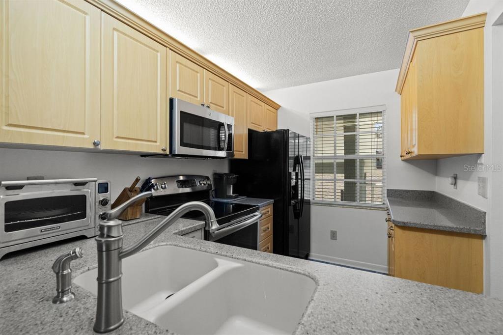1438 Millstream Lane, Unit 203 Dunedin, FL 34698 - Photo 14 of 60 a kitchen with a sink appliances and cabinets