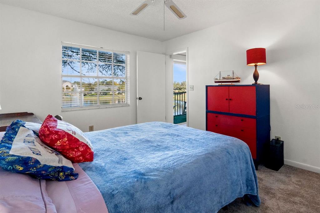 1438 Millstream Lane, Unit 203 Dunedin, FL 34698 - Photo 20 of 60 a bedroom with a bed and wooden floor